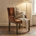 Fauteuil en velours robin des bois caramel avec un plaid dessus